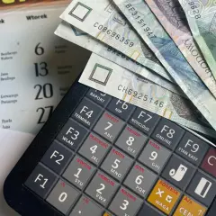 Kalkulator, banknoty i kalendarz. Planowanie wydatków na świadczenie urlopowe.