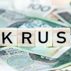Litery KRUS na tle polskich banknotów. Zastanawiasz się, ile wynosi emerytura z KRUS?