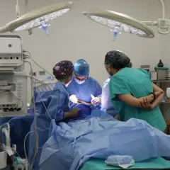 Zespół medyczny, w tym pielęgniarka anestezjologiczna, pracuje przy pacjencie na sali operacyjnej.