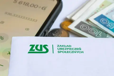 ZUS, pieniądze i kalkulator na ekranie telefonu sugerują rozważania o rencie bez lat pracy.