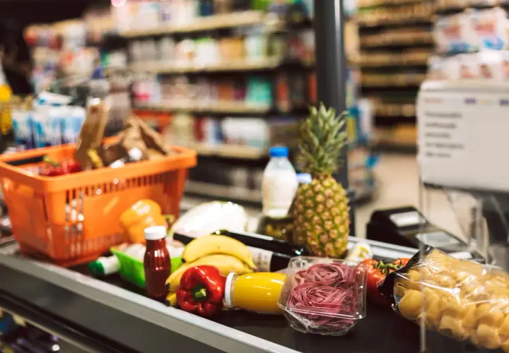 Zakupy spożywcze na taśmie: koszyk, owoce, warzywa, makaron, napoje. To typowe produkty FMCG, czyli szybko zbywalne towary.