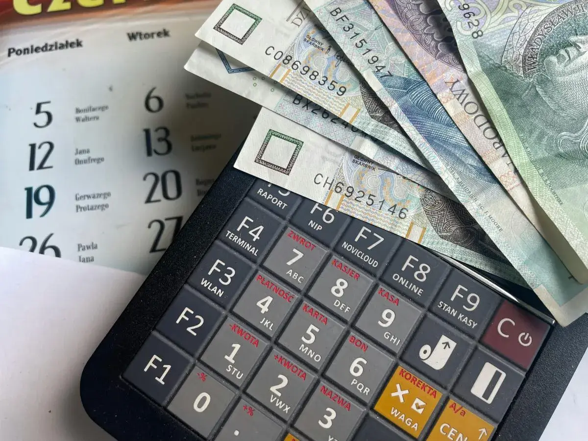 Kalkulator, banknoty i kalendarz. Planowanie wydatków na świadczenie urlopowe.