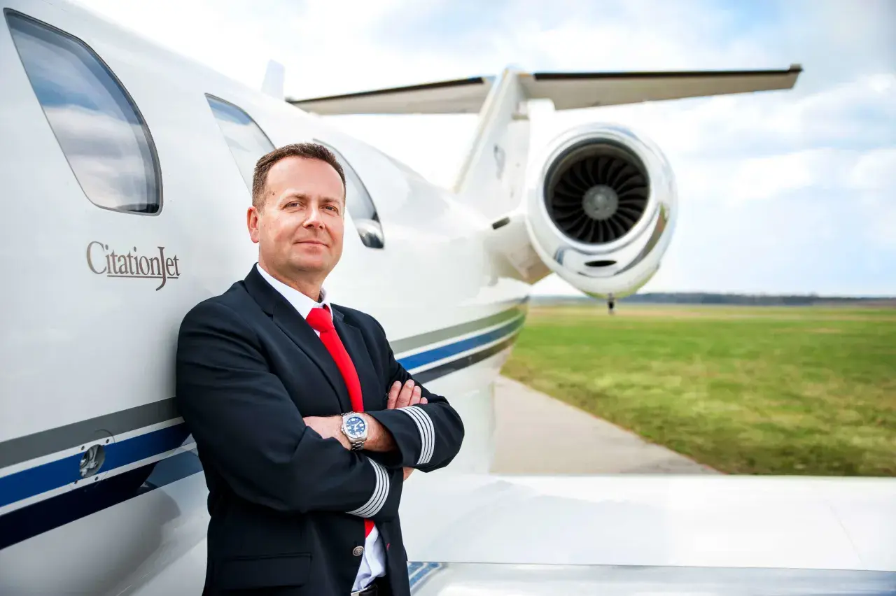 Pilot w mundurze przy CitationJet. Marzysz, jak zostać pilotem samolotu pasażerskiego? To zdjęcie może być inspiracją.
