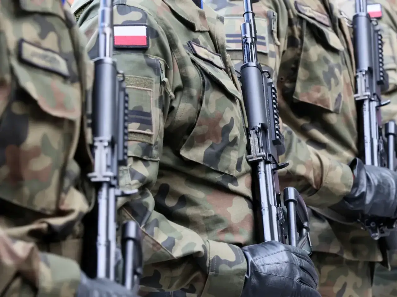 Żołnierze w mundurach trzymają broń. Zastanawiasz się, ile wynosi emerytura wojskowa po 15 latach służby?